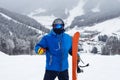 Close up portrait guy holding orange snowboard in winter