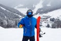 Close up portrait guy holding red snowboard in winter