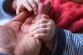 A close up portrait of the hand of a father being held by the little baby hands of his child. The small cute fingers are rapped Royalty Free Stock Photo