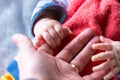 A close up portrait of the hand of a father being held by the small baby hands of his child. The little cute fingers are rapped Royalty Free Stock Photo