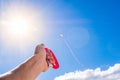 Close up and portrait of hand holding a flying kite in the blue sky - freedom lifestyle and concept