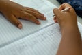 Close-up portrait of the hands of a public school student writing in a notebook. City of Salvador, Bahia Royalty Free Stock Photo