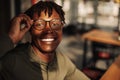 Close-up portrait of handsome African American man wearing glasses, smiling and looking at camera Royalty Free Stock Photo