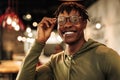 Close-up portrait of handsome African American man wearing glasses, smiling and looking at camera Royalty Free Stock Photo