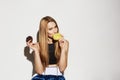 Close up portrait of handsome blonde girl in sport wear holding donuts in hands, looking in camera with flirty and