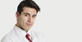 Close-up portrait of a handsome Indian male doctor smiling over light gray background Royalty Free Stock Photo