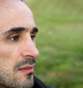 Close up portrait of a handsome man looking away on blurry green background