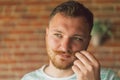 Close up portrait of handsome manly guy with beard and mustache looking in camera and happily smiling Royalty Free Stock Photo