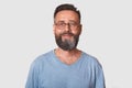 Close up portrait of handsome middle aged bearded Caucasian man with smile, male wearing gray casual t shirt, posing isolated over Royalty Free Stock Photo