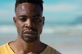 Close-up portrait of handsome serious confident african american young man at beach on sunny day Royalty Free Stock Photo