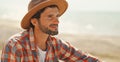 close up portrait of handsome stylish casual man traveler in hat sitting at sea coastline and enjoying peaceful nature Royalty Free Stock Photo