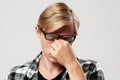 Close up portrait of handsome tired blond young man in glasses wearing casual plaid shirt isolated on white background Royalty Free Stock Photo