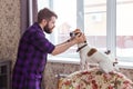 Close Up portrait handsome young hipster man plays and loves his good friend dog at home. Positive human emotions Royalty Free Stock Photo