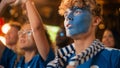 Close Up Portrait of a Handsome Young Soccer Fan with Painted Blue and White Face Standing in a Royalty Free Stock Photo
