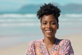 Close-up portrait of happy african american young woman with short curly hair against sea in summer Royalty Free Stock Photo