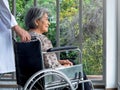 Close-up portrait of happy Asian elderly senior female patient sits in wheelchair while man doctor in white coat. Royalty Free Stock Photo