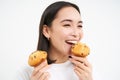 Close up portrait of happy, beautiful smiling woman, eating pastry cupcake, likes bakery, white background