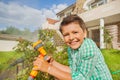 Happy boy watering garden with hand sprinkler Royalty Free Stock Photo