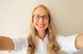 Close up portrait of happy cheerful caucasian middle-aged woman in eyeglasses stretching her hands for taking selfie with mobile Royalty Free Stock Photo