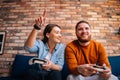 Close-up portrait of happy cheerful young couple holding controllers and playing video games on console sitting together Royalty Free Stock Photo