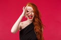 Close-up portrait of happy and excited good-looking redhead girl telling to grab your chance, show peace sign on eye and