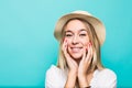 Close up portrait of a happy excited young woman in beach hat isolated over blue background Royalty Free Stock Photo