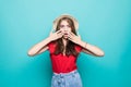 Close up portrait of a happy excited young woman in beach hat with mouth open looking at camera over blue background Royalty Free Stock Photo