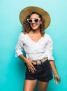 Portrait of a happy excited young woman in beach hat and sunglasses looking at camera over blue background Royalty Free Stock Photo