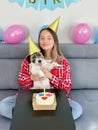 Close-up Portrait of a happy girl with her funny pet dog Jack Russell Terrier dog celebrating her birthday at home. Design by cake Royalty Free Stock Photo