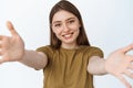 Close up portrait of happy girl hugging you, stretching out hands towards camera and smiling, reaching arms to hold