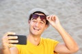 Happy man with hat and sunglasses taking selfie at the beach Royalty Free Stock Photo