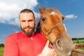 Close-up portrait of happy man with his bay horse Royalty Free Stock Photo