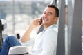 Close up happy man sitting on floor and talking on mobile phone Royalty Free Stock Photo