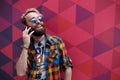 Close up portrait of happy mature guy talking on cell phone and smiling, isolated on a colorful background.