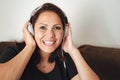 Close up portrait of happy mid adult woman wearing headphones while enjoying music at home Royalty Free Stock Photo