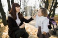 Close up portrait of happy mom and child baby girl, having fun in beautiful autumn park at sunny day, playing, smiling Royalty Free Stock Photo