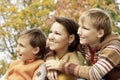 Happy mother and sons in the autumn park