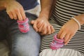 Close up portrait of happy pregnant woman together with husband holding small baby shoes, hugging in summer park Royalty Free Stock Photo