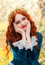 Close-up portrait happy red-haired woman queen in golden crown on head looking at camera. Girl joyful cheerful princess