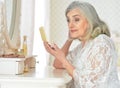 Close up portrait of happy senior woman sitting near dressing table Royalty Free Stock Photo