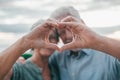 Close up portrait happy sincere middle aged elderly retired family couple making heart gesture with fingers, showing love or Royalty Free Stock Photo