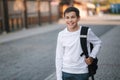 Close up portrait of happy smiled teenage boy in white sweatshirt with backpack outside Royalty Free Stock Photo