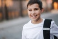 Close up portrait of happy smiled teenage boy in white sweatshirt with backpack outside Royalty Free Stock Photo