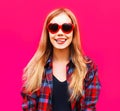 close-up portrait happy smiling blonde woman in heart shaped red sunglasses on colorful pink