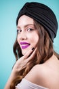 Close up portrait of happy smiling brunette woman in a black hat on blue background. Royalty Free Stock Photo