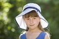 Close-up portrait of happy smiling little girl in a big hat. Child having fun time outdoors in summer Royalty Free Stock Photo