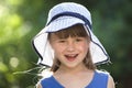 Close-up portrait of happy smiling little girl in a big hat. Child having fun time outdoors in summer Royalty Free Stock Photo