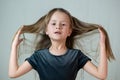 Close-up portrait of happy smiling little girl holding in hands her long hair Royalty Free Stock Photo