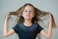 Close-up portrait of happy smiling little girl holding in hands her long hair Royalty Free Stock Photo