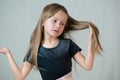 Close-up portrait of happy smiling little girl holding in hands her long hair Royalty Free Stock Photo